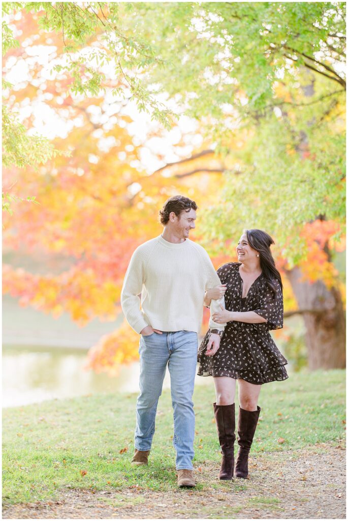 The couple embraces playfully at Bartlet Mall in Newburyport, surrounded by golden and orange autumn leaves.