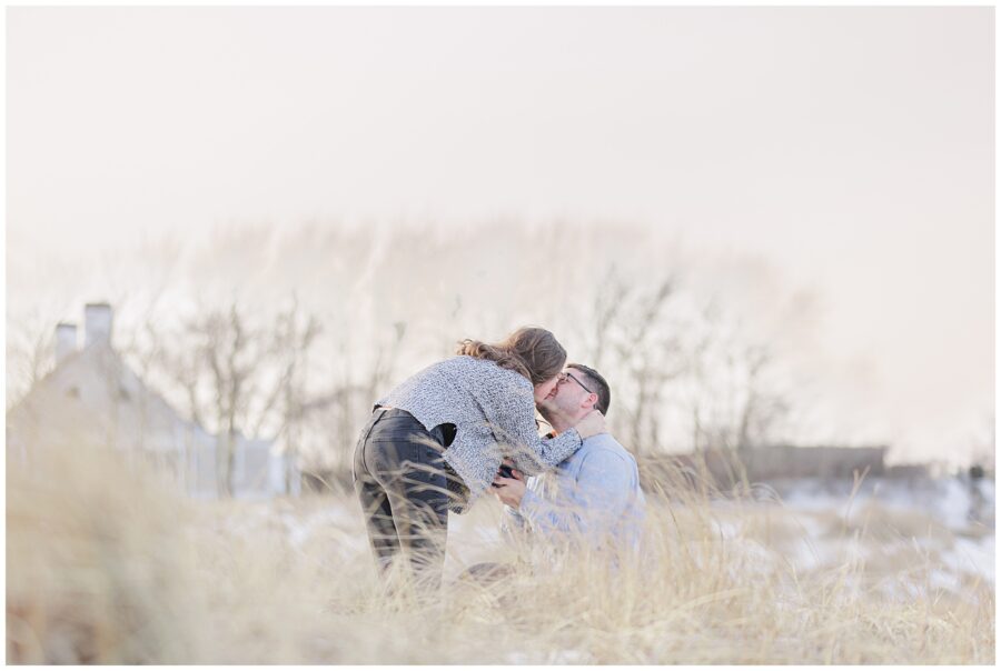 Joyful kiss after a Chatham Lighthouse Beach proposal in the beach grass at Chatham Lighthouse Beach in Chatham, MA Cape Cod.