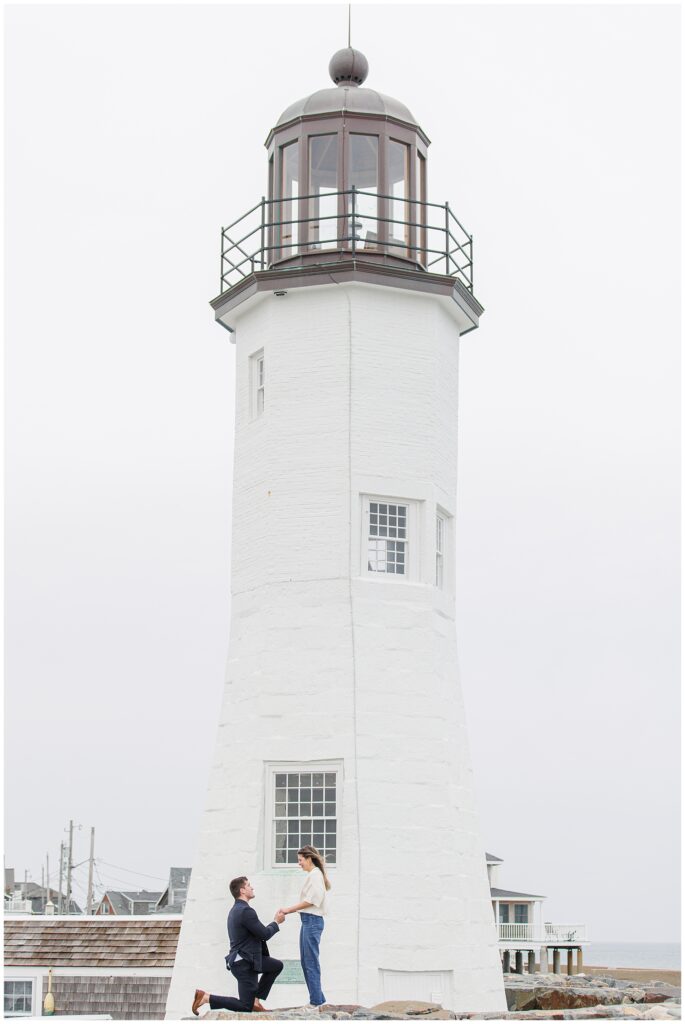 Scituate Lighthouse proposal moment with man kneeling in front of white lighthouse in Scituate MA