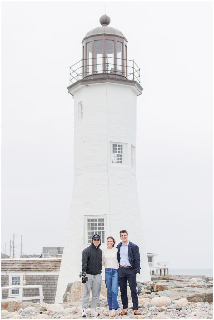 Couple and videographer portrait after Scituate Lighthouse proposal in front of lighthouse in Scituate Massachusetts