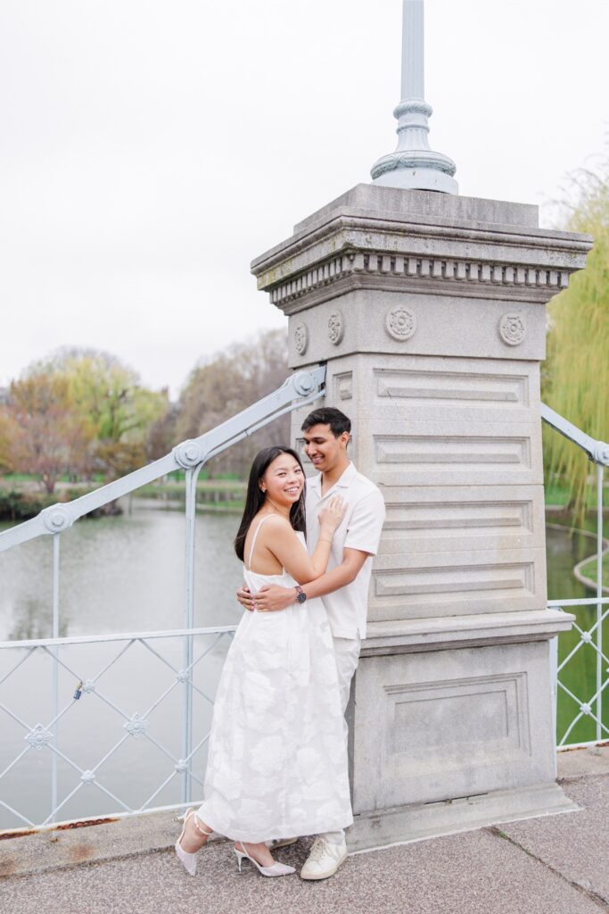     Couple embracing on the bridge in the Boston Public Garden during romantic Beacon Hill engagement photos