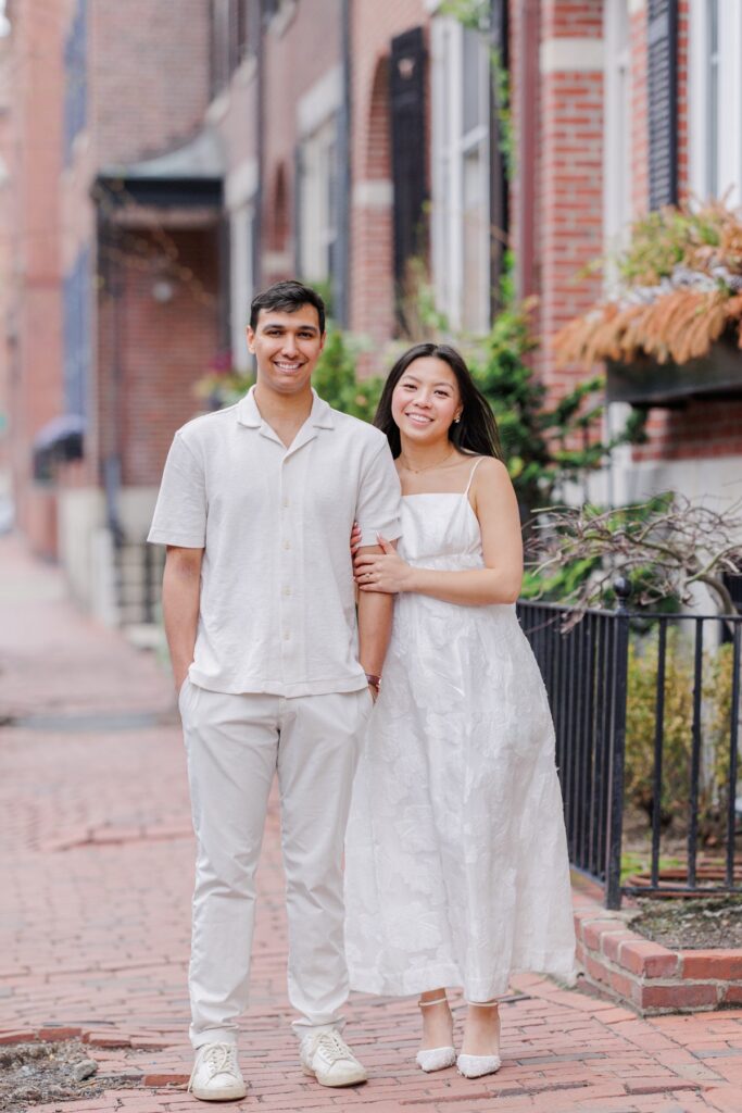     Couple smiling together on a historic Beacon Hill street during romantic Beacon Hill engagement photos in Boston