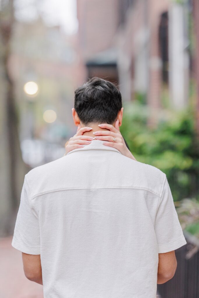     Close-up of engagement ring and bride’s hands wrapped around groom’s neck during Beacon Hill engagement photos