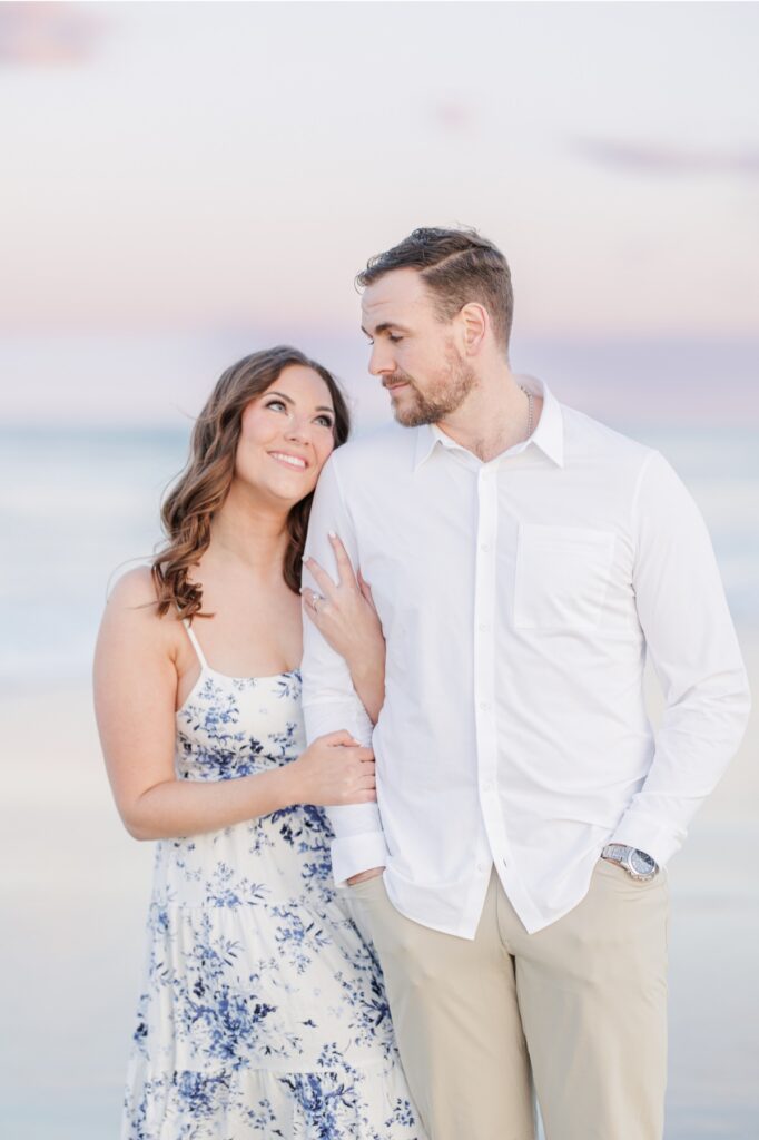     Elegant beach engagement portrait of a couple embracing at sunset in Seabrook, New Hampshire.