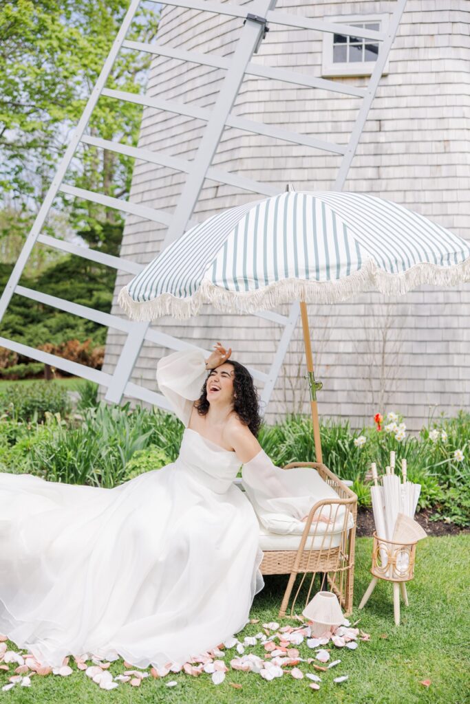 Laughing bride in a flowing wedding gown near the windmill at Heritage Museum and Garden wedding venue