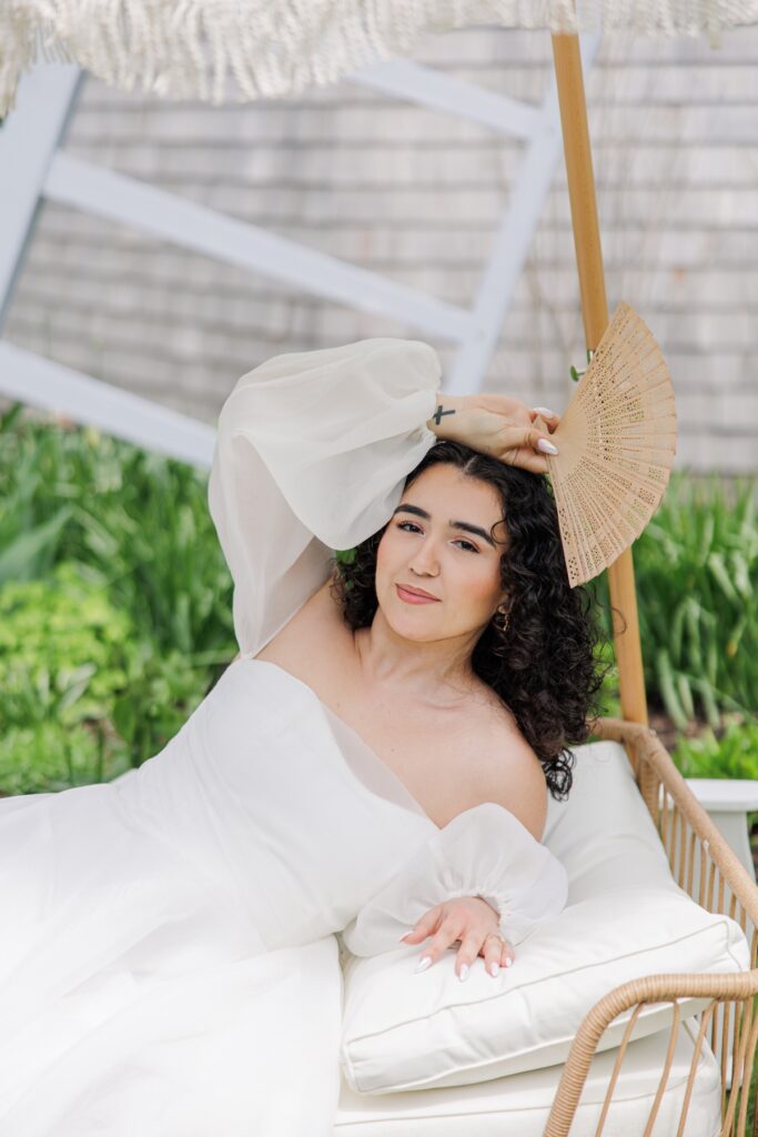Bridal portrait with hand fan beside the historic windmill at Heritage Museums & Gardens