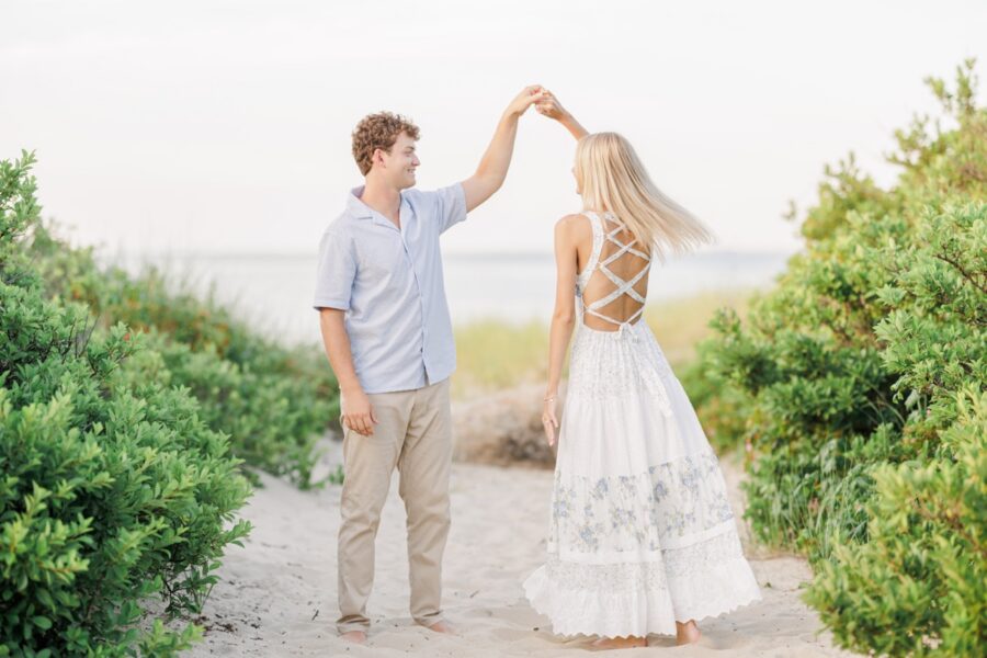 Bride-to-be twirling in a flowing dress during Cape Cod beach photos.