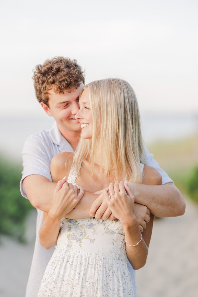 Couple embracing during golden hour on a quiet Cape Cod beach.