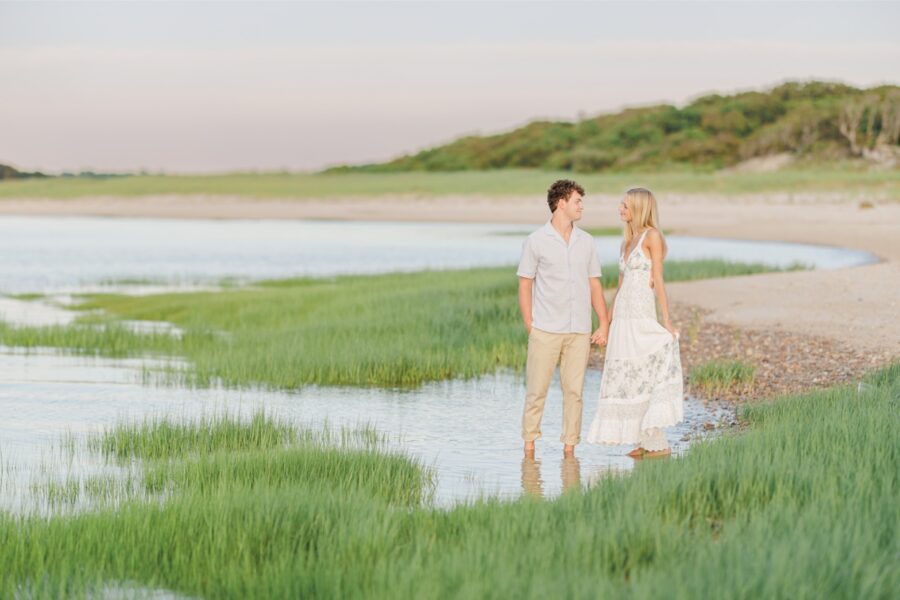 Couple standing barefoot in a Cape Cod salt marsh during their engagement session.