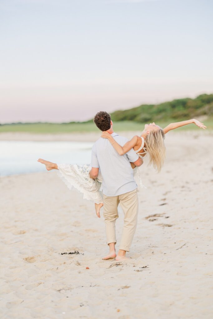 Couple dancing barefoot in a Cape Cod salt marsh during golden hour.