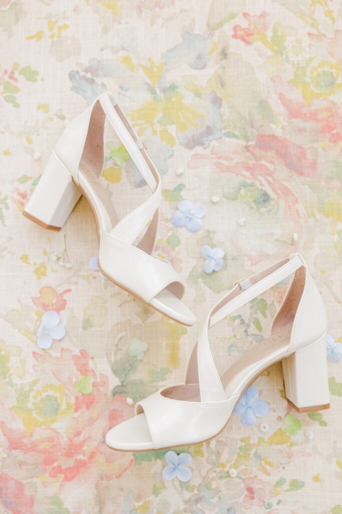White block-heel bridal shoes styled with blue flowers for a Publick House wedding.