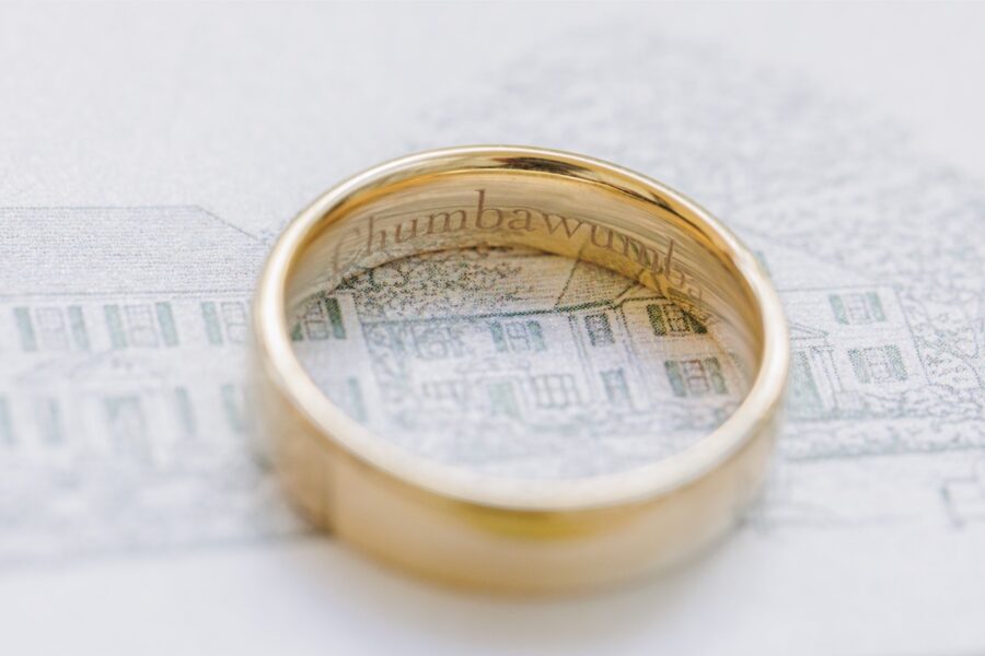Gold wedding band resting over an illustration of the Publick House Historic Inn.