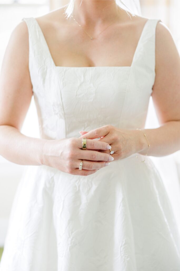 Bride wearing heirloom rings with her square-neck wedding gown.