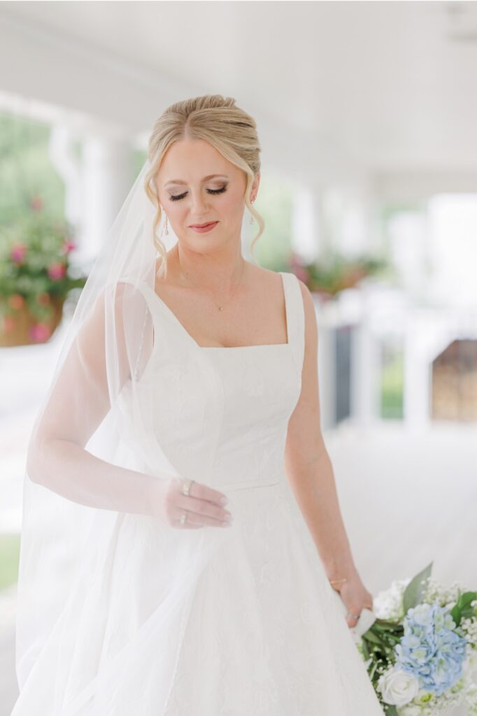 Bridal portrait with a delicate veil and blue hydrangea bouquet in Sturbridge, Massachusetts.