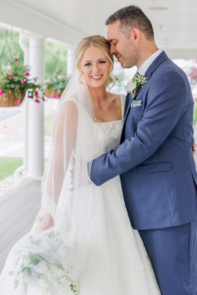 Bride and groom embracing on the porch during their Publick House wedding.