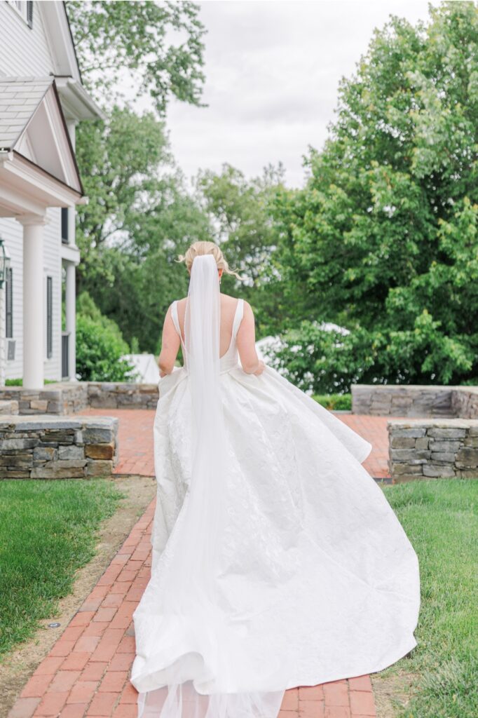 Bride walking along a brick path in her wedding gown at the Publick House in Sturbridge.