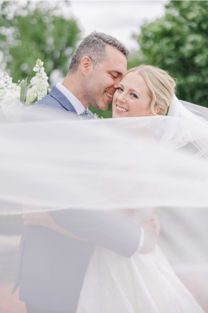 oyful Publick House wedding portrait of the bride and groom beneath her flowing veil.