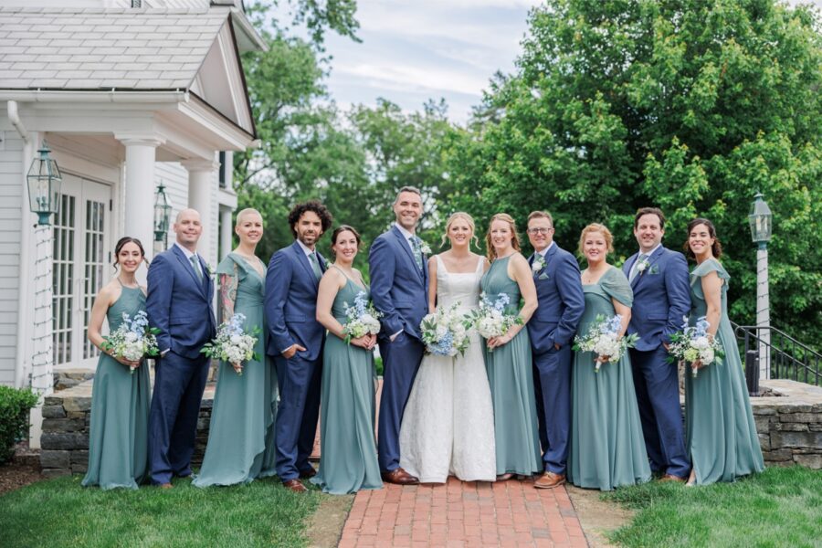 Wedding party in sage green and navy poses outside the Publick House in Sturbridge.