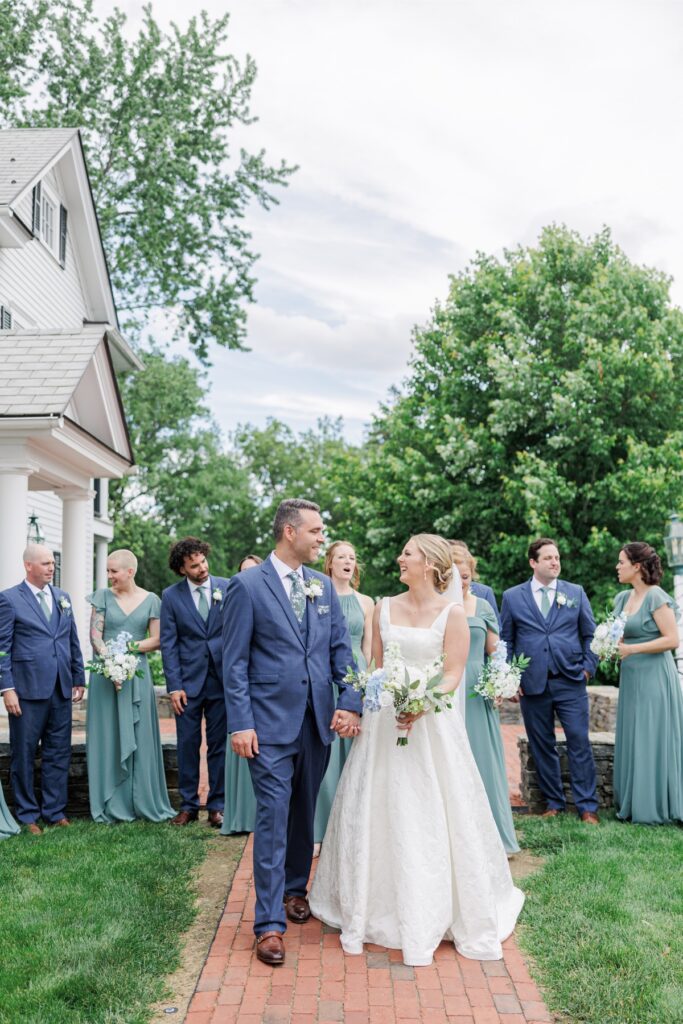 Bride and groom laugh while walking with their wedding party at the Publick House.