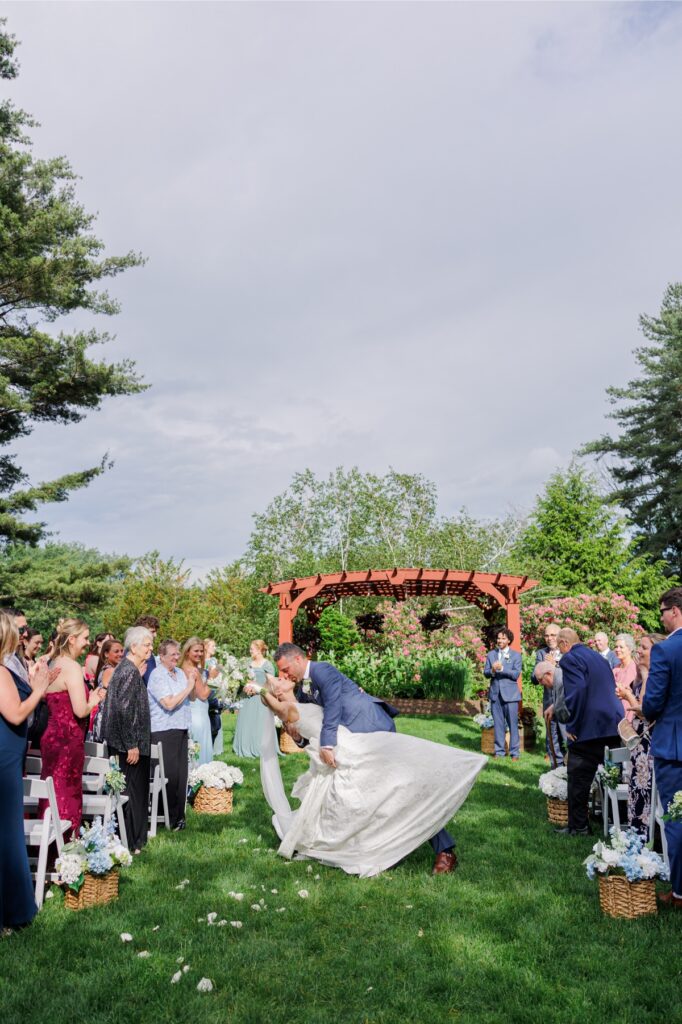 Groom dips and kisses the bride as they leave their Publick House wedding ceremony.