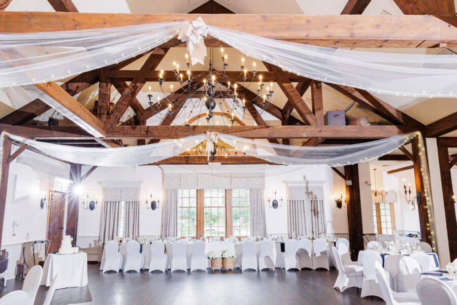 Paige Hall reception space with exposed beams and chandeliers at the Publick House Historic Inn.