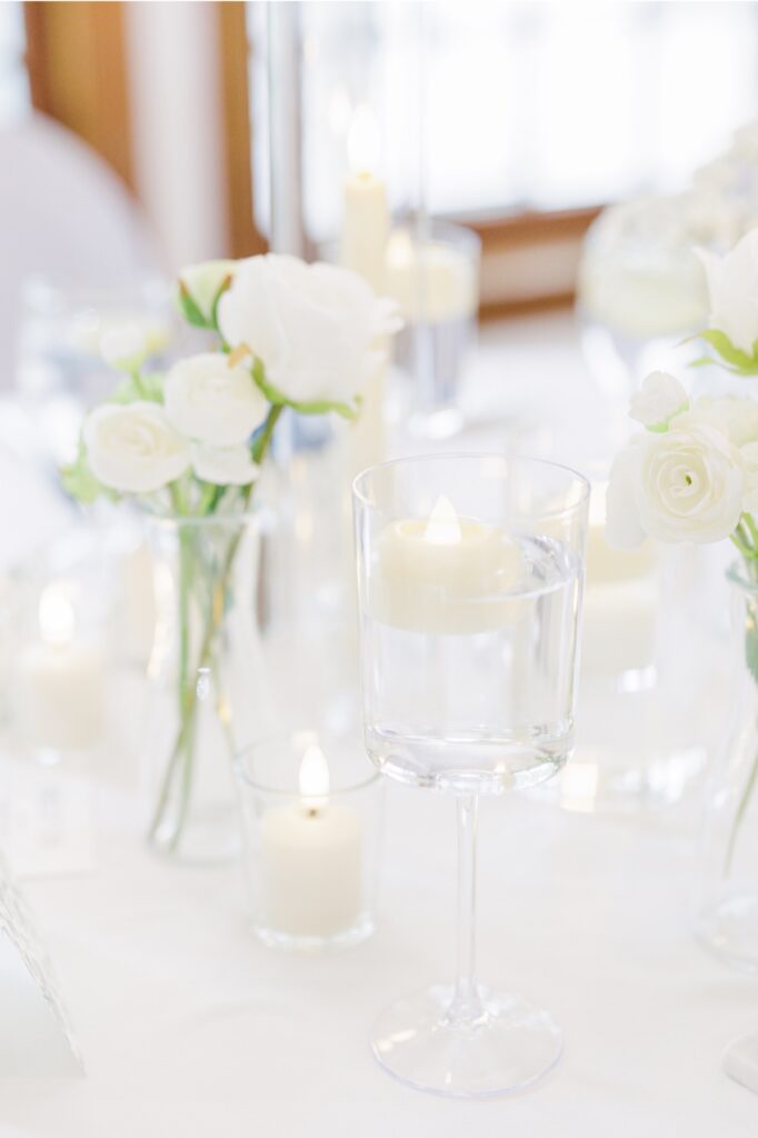 Floating candles and white floral centerpieces decorate a Publick House wedding reception.