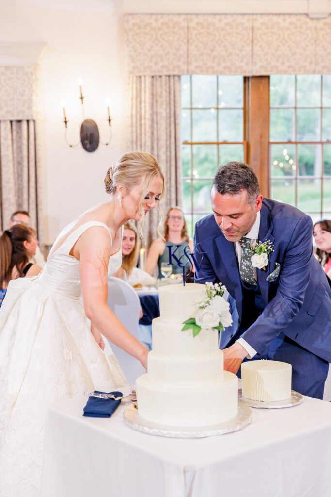 Bride and groom cut their tiered white wedding cake at the Publick House reception.