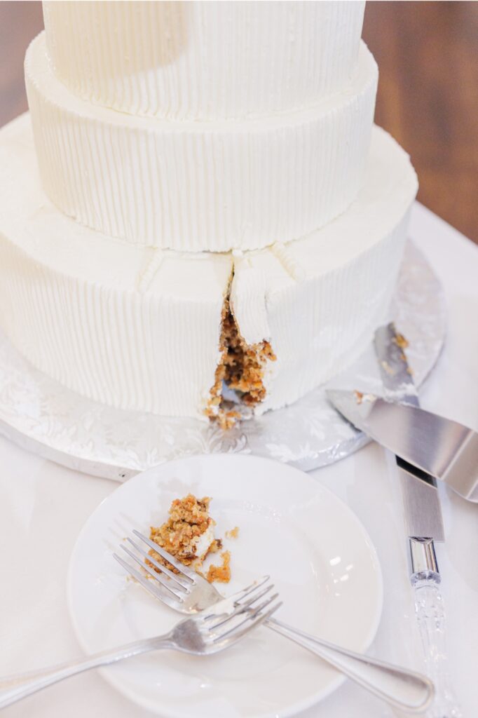 Slice cut from a tiered white wedding cake at the Publick House reception.