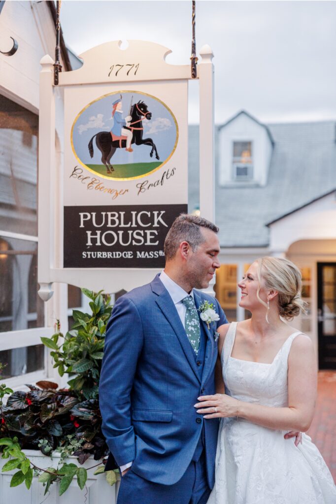 Bride and groom pose beneath the historic Publick House sign in Sturbridge.