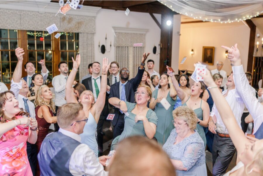 Wedding guests toss playing cards into the air during the Publick House reception.