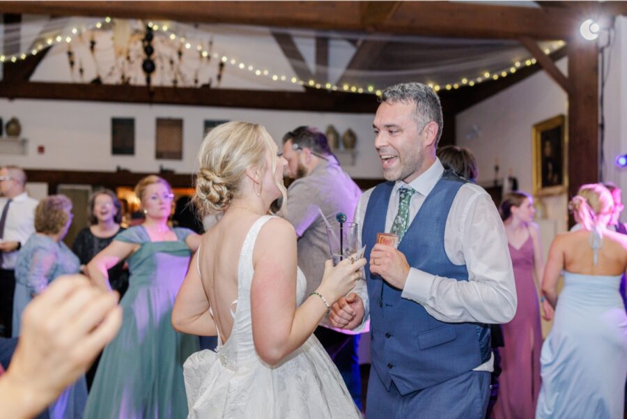 Bride and groom laugh together on the dance floor during their Publick House wedding.