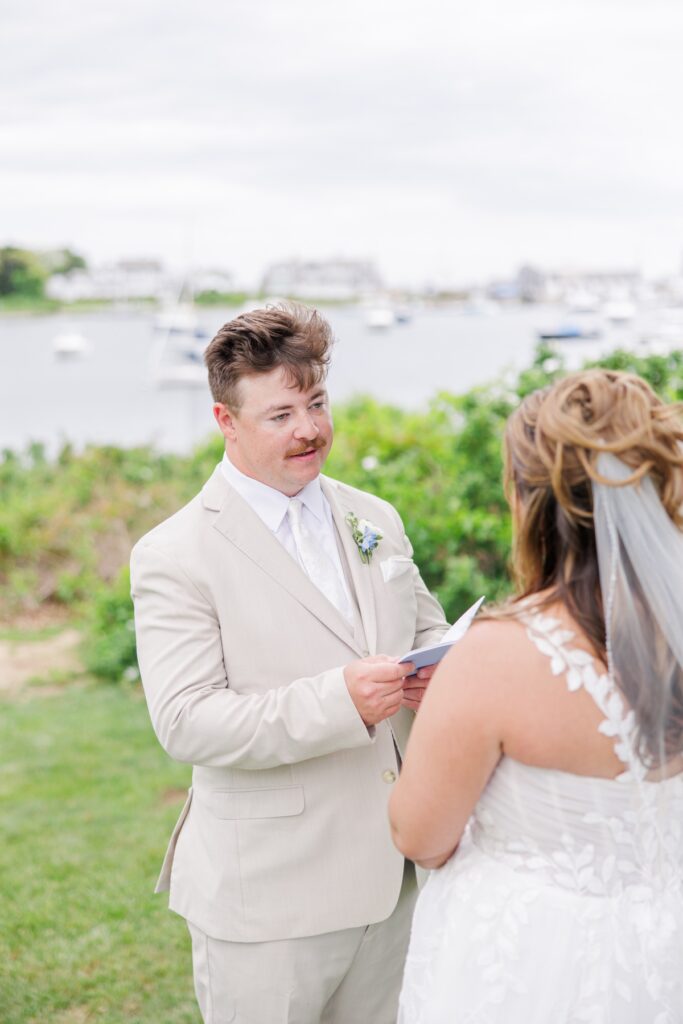 The groom reads a handwritten letter to the bride during their private first look overlooking Wychmere Harbor. The quiet exchange creates an intimate moment before their Wychmere Beach Club wedding ceremony.