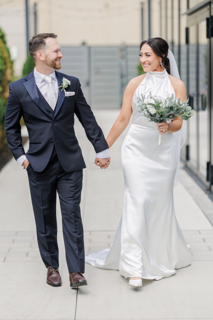 The bride and groom walk hand in hand during portraits around the hotel grounds.