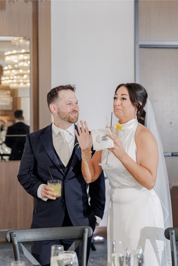 The bride and groom smiling with cocktails during their Artisan Hotel reception.