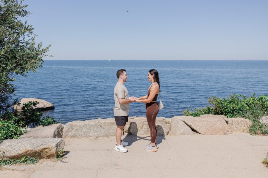 Couple holding hands before a surprise proposal at The Knob on Cape Cod.