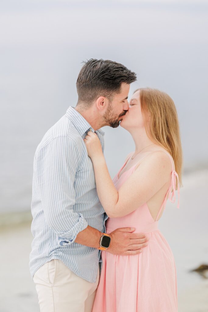 Amy and Joe share a kiss on the shore at Mayflower Beach in Dennis, Massachusetts.
