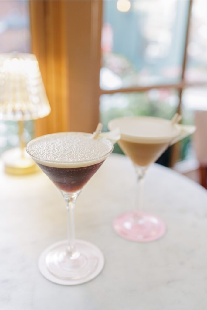 Two espresso martinis on a marble table inside Ciao Roma in Boston’s North End