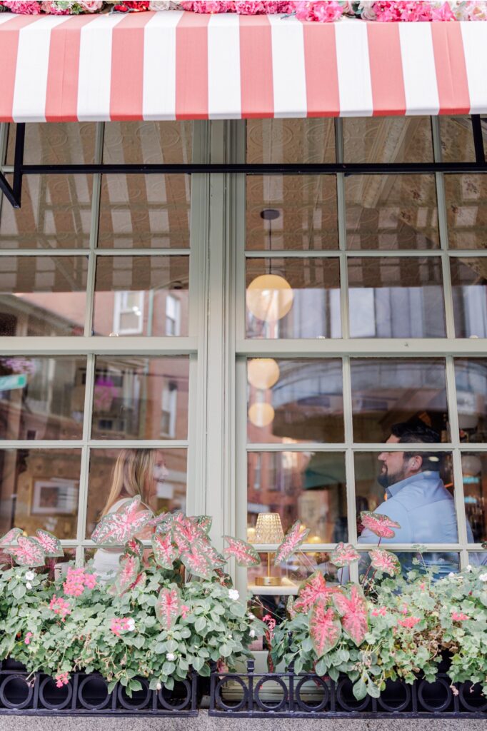 Pink-and-white striped awning and flower boxes outside Ciao Roma in Boston’s North End