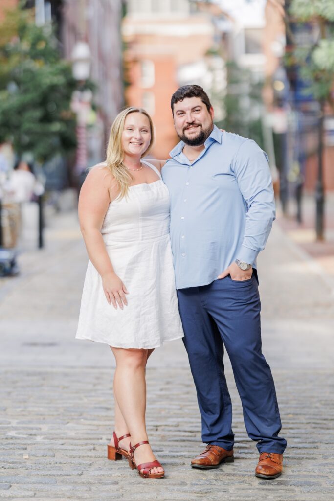 The engaged couple embracing on a cobblestone street during their Boston North End engagement photos