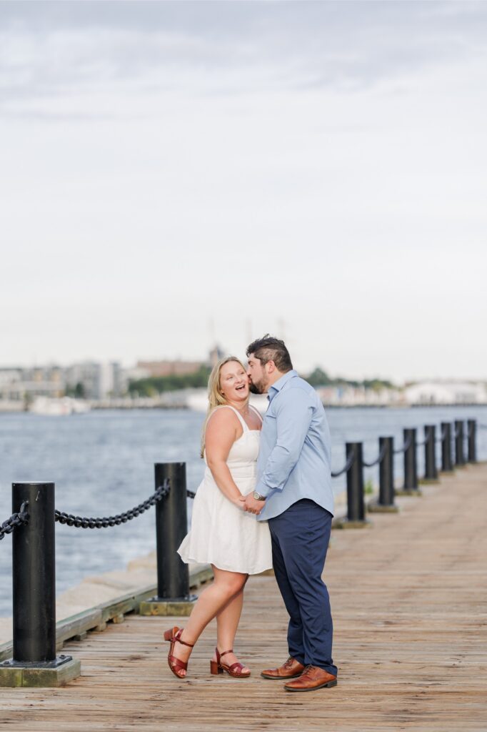 The engaged couple laughing together along the Boston Harborwalk