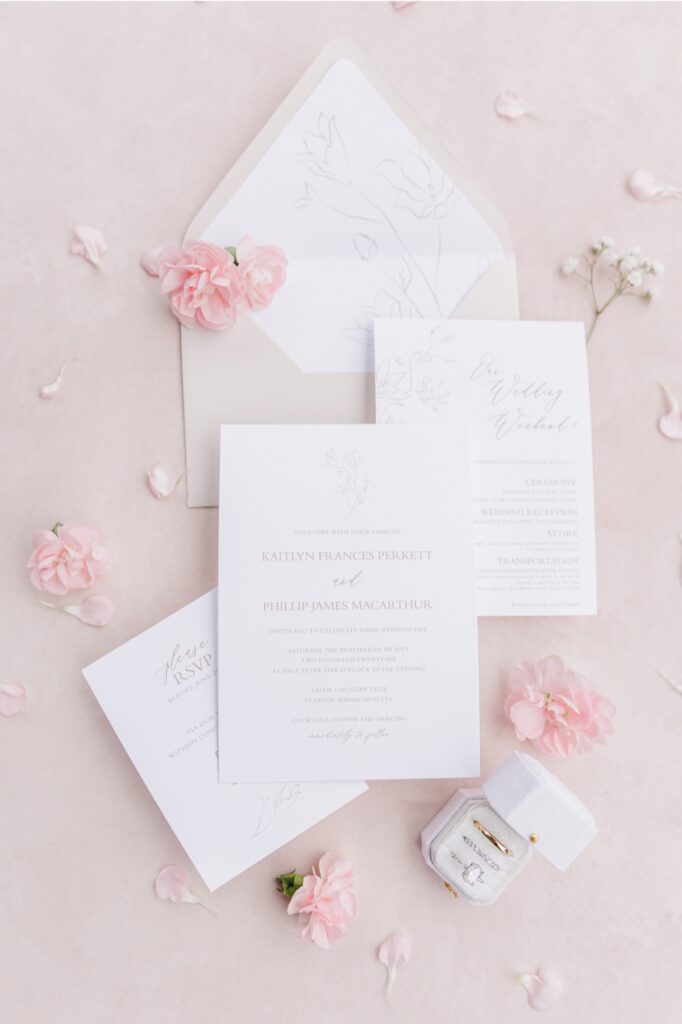 White Salem Country Club wedding invitation suite arranged with blush pink flowers.