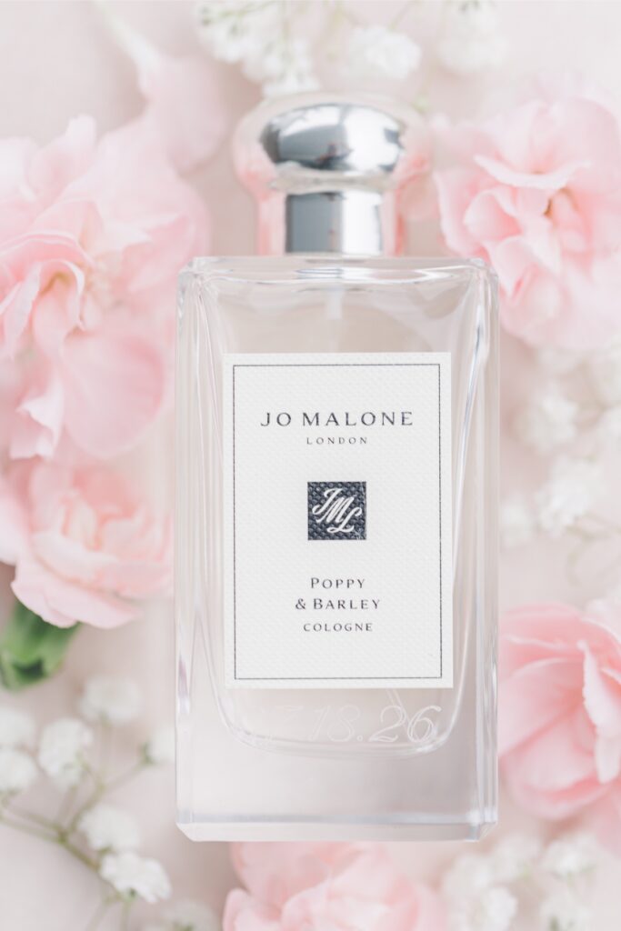 Jo Malone Poppy & Barley cologne surrounded by pink flowers among Salem Country Club wedding details.