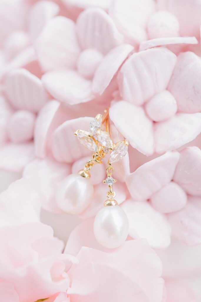 Gold and crystal bridal earrings nestled in pale pink petals for a Salem Country Club wedding.