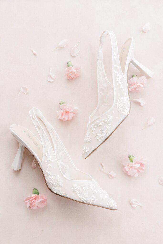 White lace bridal shoes with jeweled accents arranged among blush flowers for a Salem Country Club wedding.