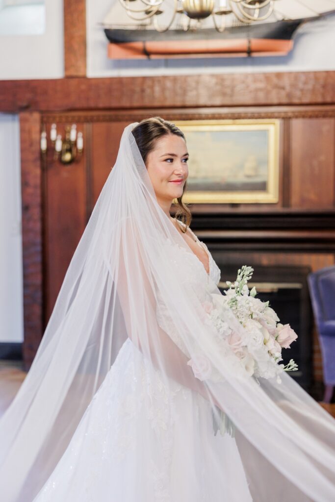 The bride wearing her long veil and holding a blush and white bouquet at her Salem Country Club wedding.