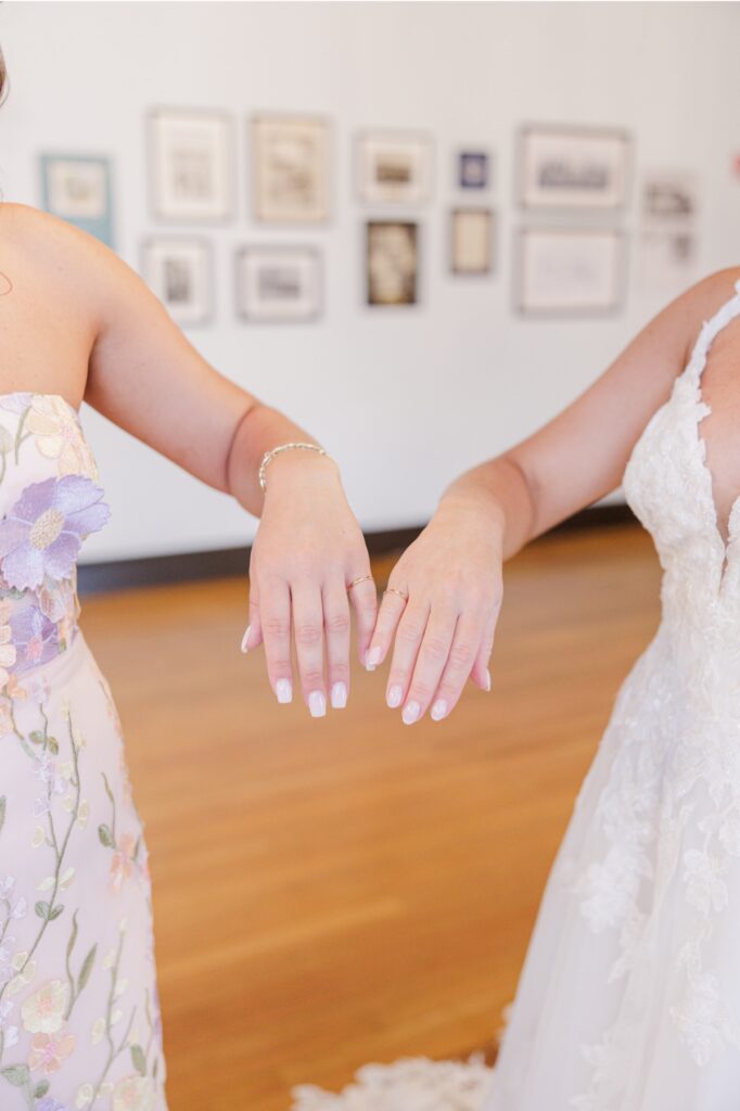 The bride and her sister showing their matching pinky rings before the Salem Country Club wedding.