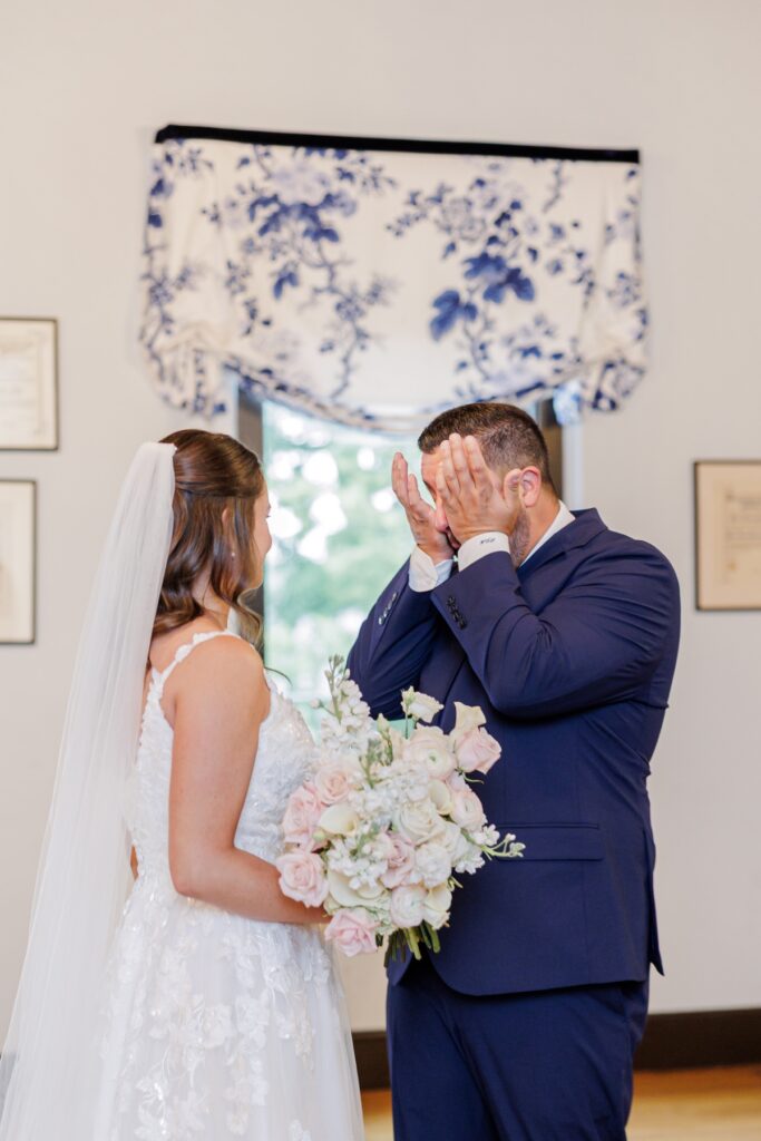 The groom wiping away tears upon seeing the bride during their Salem Country Club wedding first look.