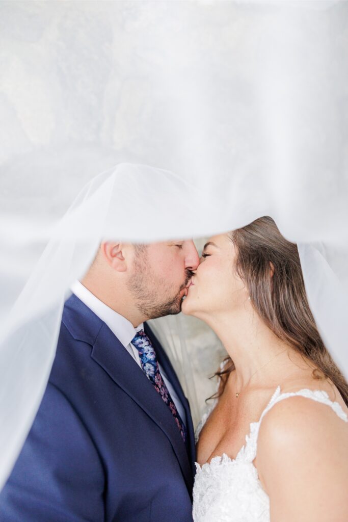 Close-up of the bride and groom kissing beneath her veil at their Salem Country Club wedding.