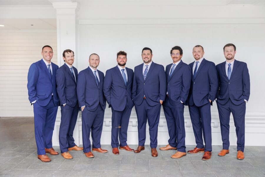 The groom and seven groomsmen in navy suits and brown shoes at the Salem Country Club wedding.