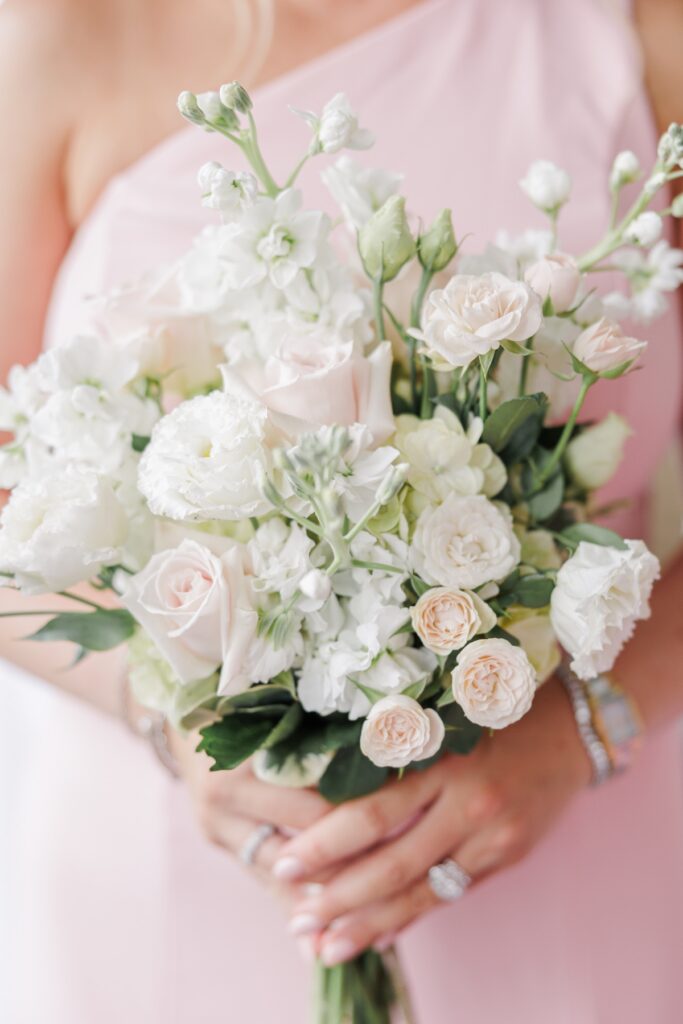 Close-up of pale roses, white flowers, and variegated greenery in a Salem Country Club wedding bouquet.